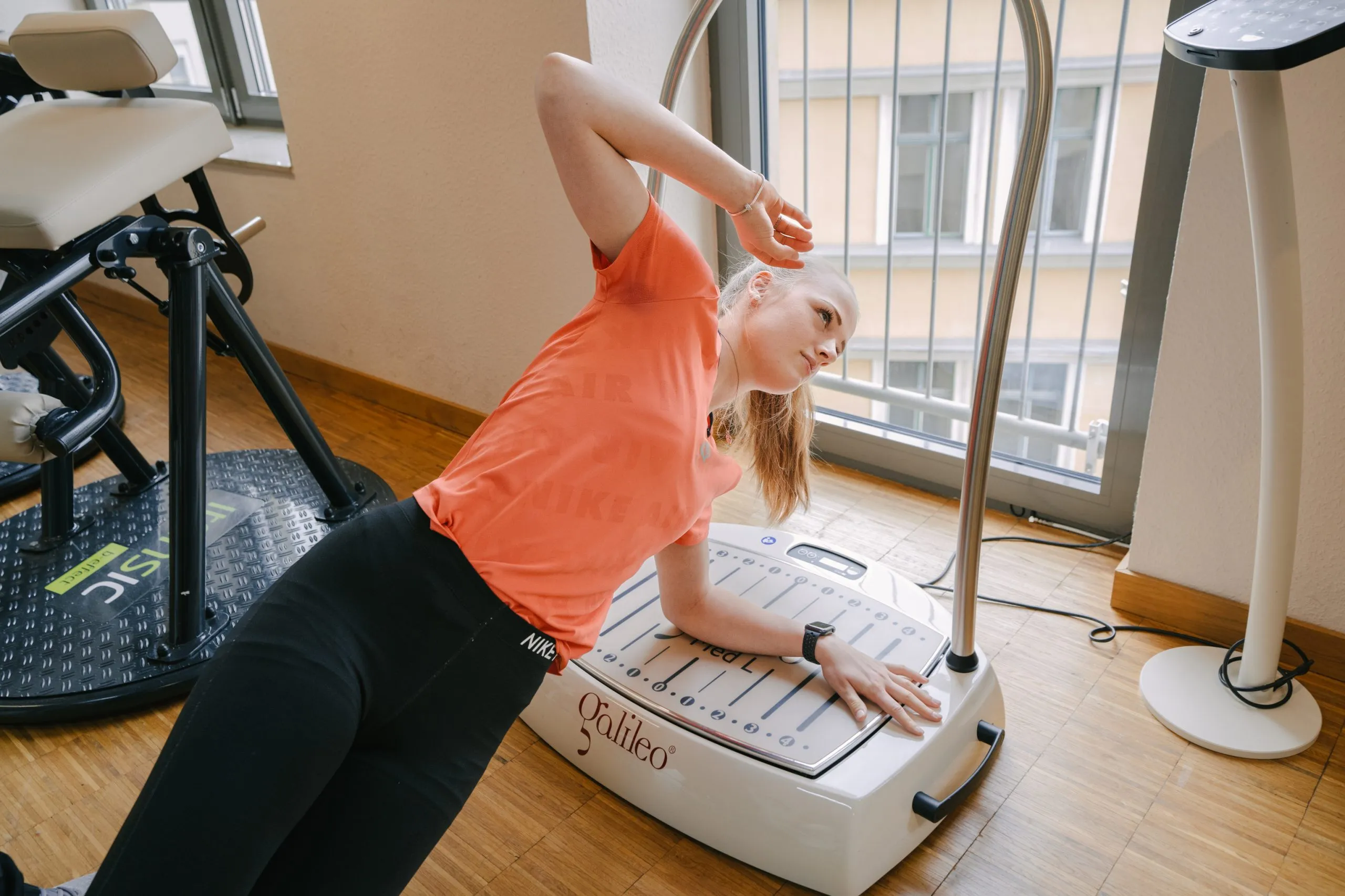 Patientin bei einer Dehnübung an einem medizinischen Trainingsgerät