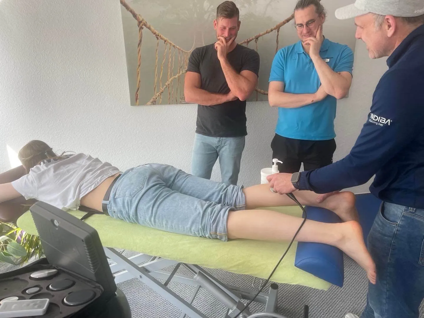 Drei Therapeuten besprechen gemeinsam eine Behandlung am Patienten