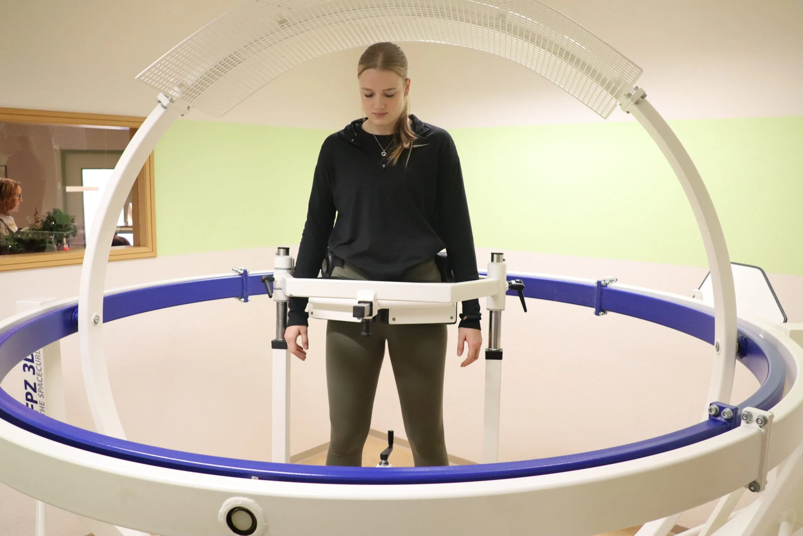 Patientin im Spacecurl, einem dreiachsigen Trainingsgerät, betreut von einem Therapeuten