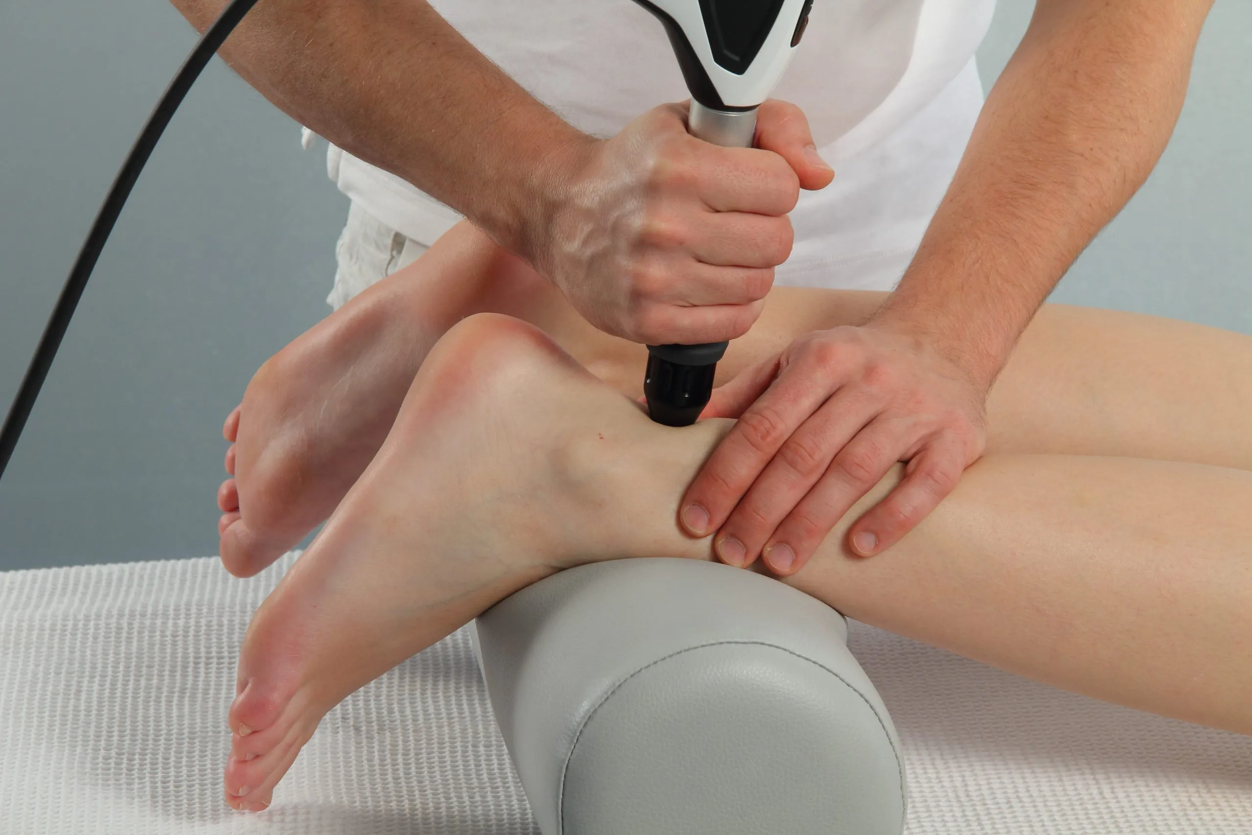 Anwendung der Stoßwellentherapie am Rücken einer Patientin